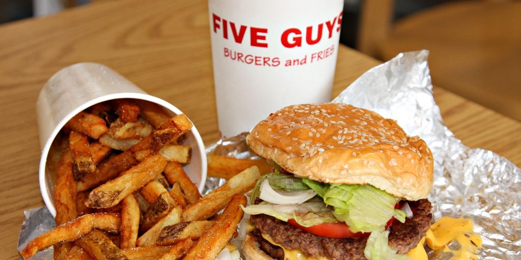 A Five Guys restaurant interior with stacked bags of potatoes